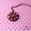 Collier fantaisie avec pendentif rond ajour&eacute; et perles roses